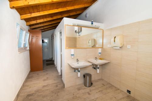 a bathroom with two sinks and two mirrors at Mobile home Banovi dvori III in Tisno