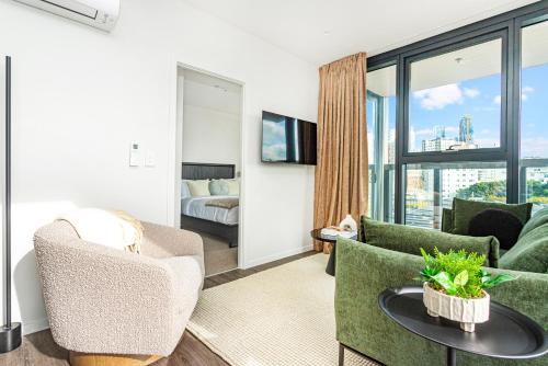 a living room with a couch and chairs at Parnell Haven 2BRM Apartment with Deck, Parking & City Views in Auckland