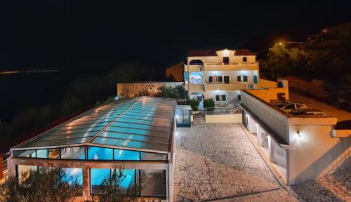 a house with a glass roof at night at Villa Casa with indoor pool in Krilo