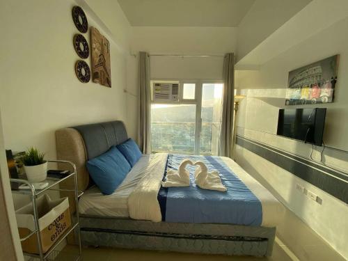 a small bedroom with a bed and a window at Twilight23 Condo in Cebu City