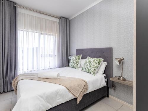 a bedroom with a large bed and a window at Binbin Serenity Suite in Midrand
