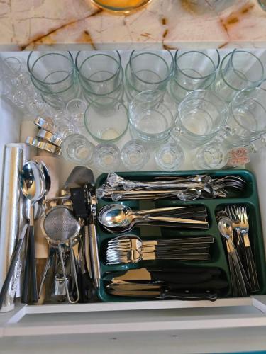 a drawer filled with silver utensils and glasses at Princess Palace in Gdańsk