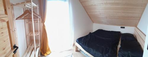 a small room with a bed and a wooden ceiling at Bobrštajn in Žacléř