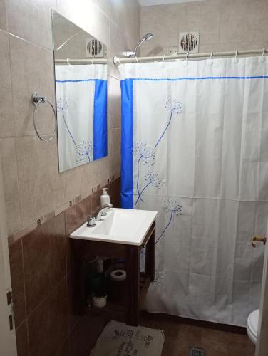 a bathroom with a shower curtain and a sink at Los Gurises in Balneario El Condor