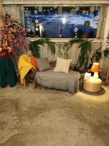 a couch with pillows sitting in a room with flowers at 有風小院 in Green Island