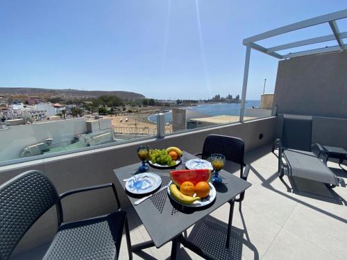 a table with bowls of fruit on a balcony at Alaram Holidays House in Arguineguín