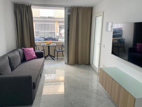 a living room with a couch and a dining room at Alaram Holidays House in Arguineguín