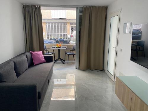 a living room with a couch and a table at Alaram Holidays House in Arguineguín