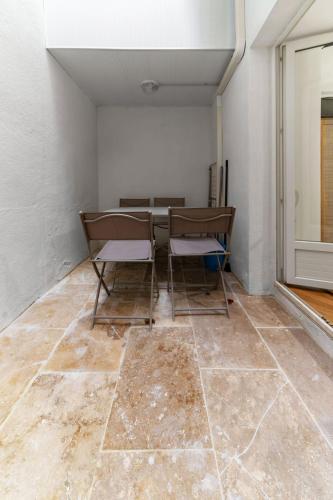 an empty room with a table and chairs on a floor at Résidence Serbie - Appartements design et climatisés en centre ville in Vichy