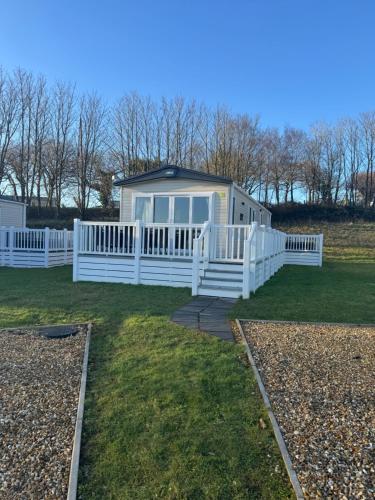a house with a white fence on a yard at Wallows Lodge with private hot tub in St Austell