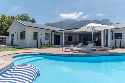 a swimming pool in front of a house at Maison la Bruyere, 8p villa - heated pool, airco & hottub in Franschhoek
