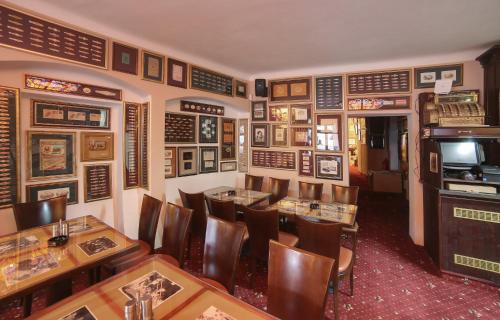 a restaurant with wooden tables and chairs and a television at Pension Masonic House in Loket