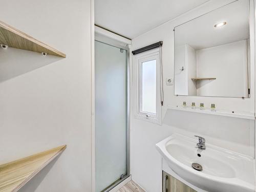 un bagno bianco con lavandino e specchio di L'Esprit Vintage, terrasse couverte a Litteau