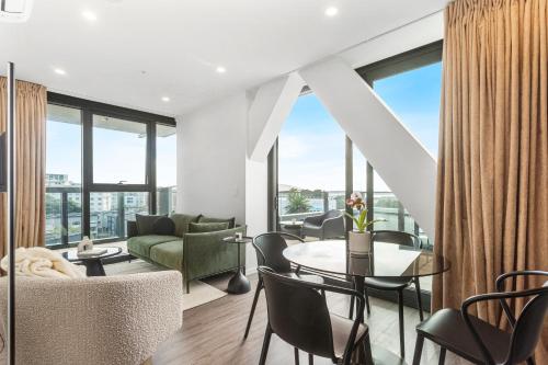 a living room with a table and chairs at Parnell Haven 2BRM Apartment with Deck, Parking & City Views in Auckland