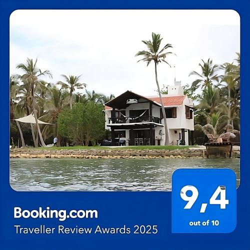 a house on the water with palm trees at Tintipan Cabana SalSiPuedes in Tintipan Island