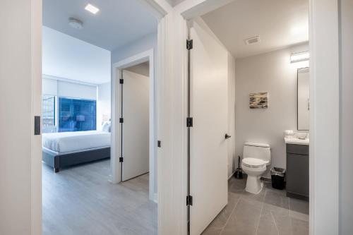 a bathroom with a toilet and a sink and a bed at Chic Apt with Indoor Pool & Gym-333-2509 in New Rochelle