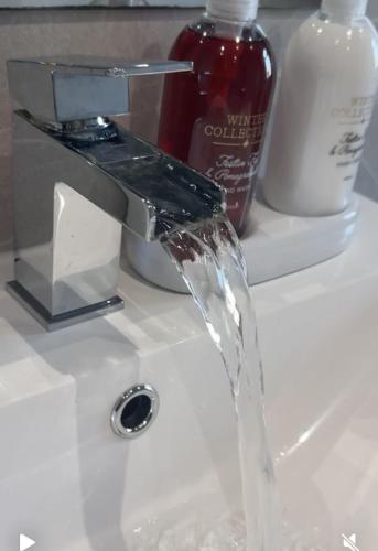 a sink with water coming out of a faucet at Tomelle Manchester in Manchester
