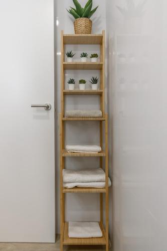 a wooden shelf with towels and a plant at Laguna Home in Ayamonte