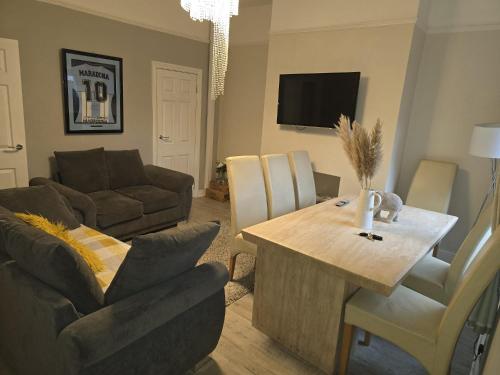 a living room with a table and a couch at Tomelle Manchester in Manchester