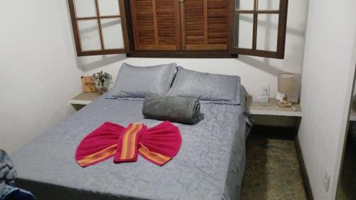 1 dormitorio con 1 cama con arco rojo en Aconchego da Cachoeira, en Paraty