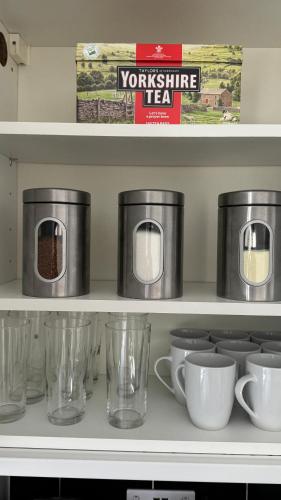a shelf with glasses and cups on it at Little Luxe shared house in Bristol