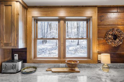 a kitchen with a window with snow outside of it at Shawnee Ridge Lodge in Banner Elk