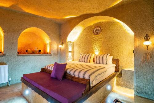 a bedroom with a bed in a stone room at CAPPANAR CAVE HOTEL in Nar