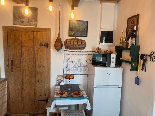 a kitchen with a refrigerator and a table with food on it at Kunyhó in Egeraracsa