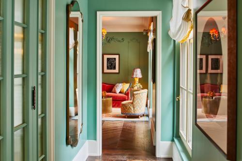 a hallway with green walls and a living room at The Fifth Avenue Hotel in New York