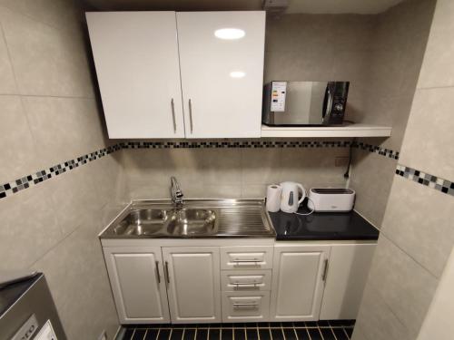 a small kitchen with a sink and a microwave at Depto calle huérfanos, Santiago in Santiago