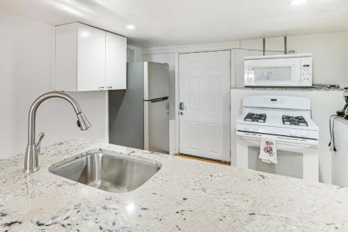 a white kitchen with a sink and a stove at 12 Mi to Dtwn Boston Apartment in Braintree in Braintree