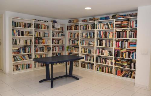 a library with a black table in front of shelves of books at Bryson Home Gigantes in Puerto de Santiago