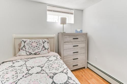a bedroom with a bed and a dresser at 12 Mi to Dtwn Boston Apartment in Braintree in Braintree