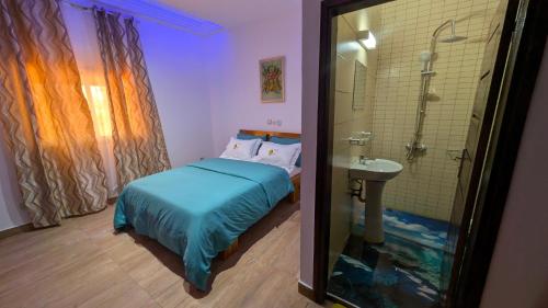 a bedroom with a bed and a shower and a sink at Complexe Singa in Bingerville