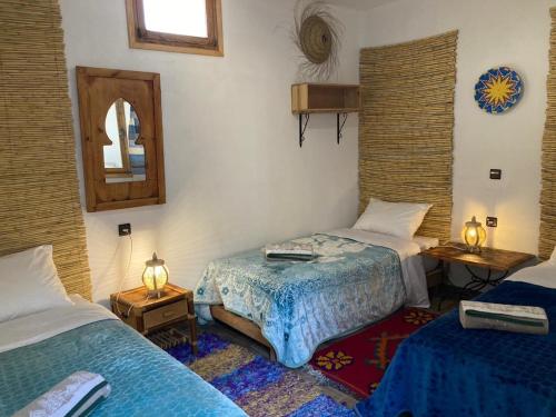 ein Zimmer mit zwei Betten und einem Spiegel in der Unterkunft Octopus house in Wassane