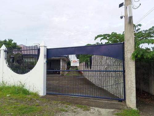 a blue gate with a sign on a fence at La Casa Alemanya in Moalboal
