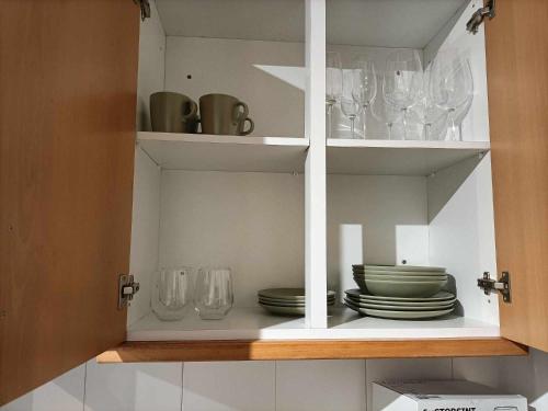 a white cabinet with plates and glasses in it at Apartamentos São Sebastião in Évora