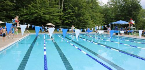 a large swimming pool with people in the water at Peaceful Pocono Lakefront, beach, pools, firepit, pets in Arrowhead Lake