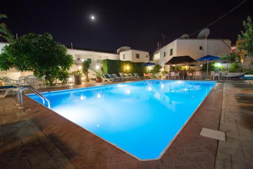 a large swimming pool at night with blue lighting at Eligonia Hotel Apartments in Ayia Napa