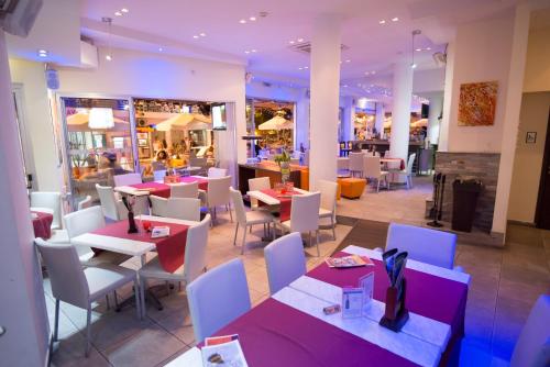 a restaurant with purple and white tables and chairs at Eligonia Hotel Apartments in Ayia Napa