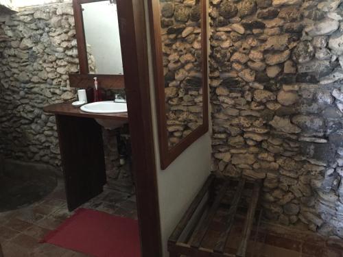 baño con lavabo y pared de piedra en La Princesa de La Isla, en Isla Grande del Maíz