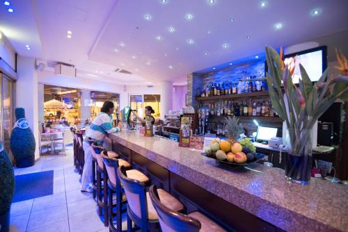 a woman standing at a bar in a restaurant at Eligonia Hotel Apartments in Ayia Napa