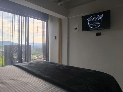 a bedroom with a bed and a large window at San Gabriel Via Termales Santa Rosa in Santa Rosa de Cabal