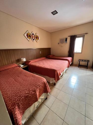a hotel room with two beds and a window at Hotel Confianza in Corrientes