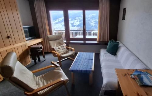 a living room with a couch and chairs and a table at Ski fahren-Schneeschuhwandern-Langlauf inkl Hallenbad in Luzein