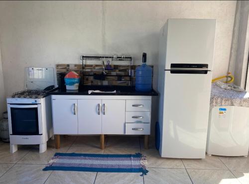 una cucina con un frigorifero bianco e una stufa di Casa da Cris em Praia do Grauçá com Wi-Fi, ar condicionado e garagem a Caravelas