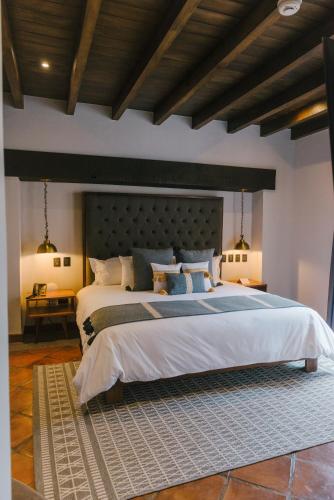 a bedroom with a large bed with a large headboard at Casa 63 Hotel Boutique & Spa in San Miguel de Allende
