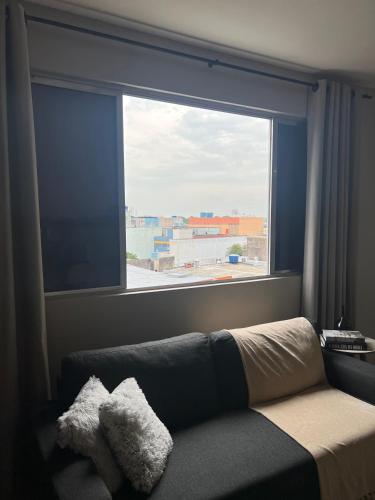 a living room with a large window and a couch at Loft in Sapucaia do Sul in Sapucaia do Sul