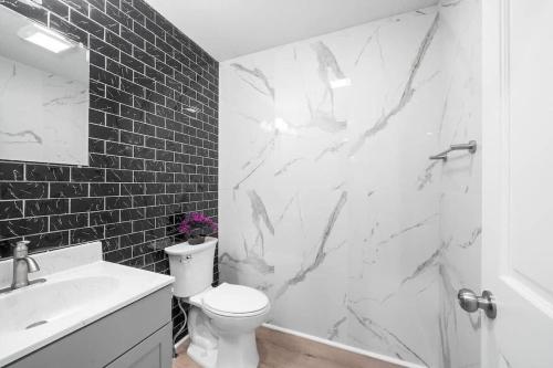 a white bathroom with a white toilet and a sink at Big Villa 6Bd 7Ba Heated Pool Hot Tub Sauna Big Game Room in Lindale