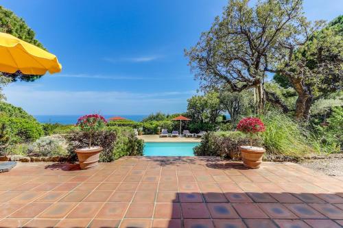 une maison avec une piscine et un parasol dans l'établissement Villa provençale face à la mer, à Sainte-Maxime